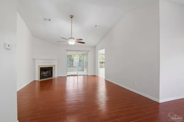 a view of empty room with wooden floor fireplace and windows