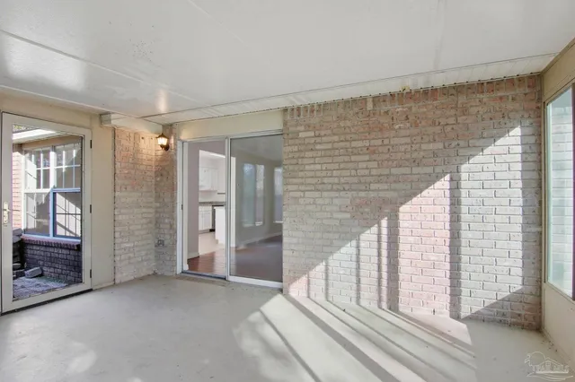 a view of a hallway with wooden floor and windows