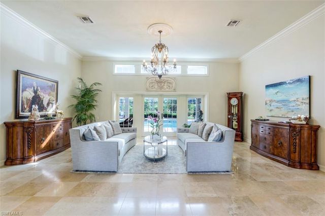 a living room with fireplace furniture and a chandelier