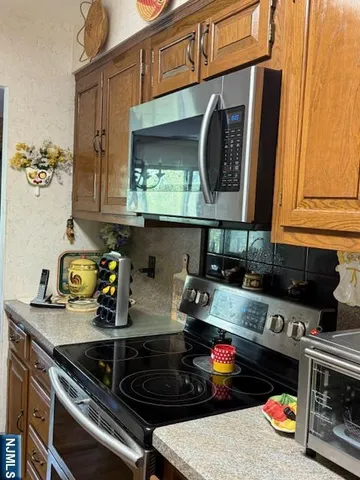 a kitchen with stainless steel appliances granite countertop a stove and a microwave
