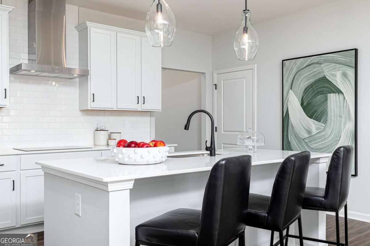 740 Coventry Cv Way Acworth, GA 30102 - Photo 29 of 41 a kitchen with a dining table chairs and white cabinets