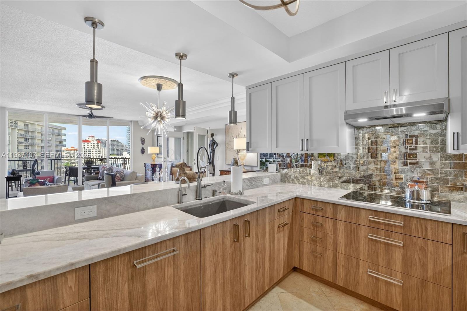 100 South Birch Road, Unit 1103F Fort Lauderdale, FL 33316 - Photo 32 of 80 Spectacular kitchen w/ custom bleached walnut veneer cabinetry by renowned Chicago based millworker. Grain matches from top to bottom. Taj mahal quartzite. Wolf induction cooktop & double oven (w/ microwave / convenction at top oven), Sub Zero Refrigerator & Beverage Cooler, Miele Dishwasher. Sink w/ touchless Brizo faucet, including water filtration faucet. Antiqued mirror backsplash