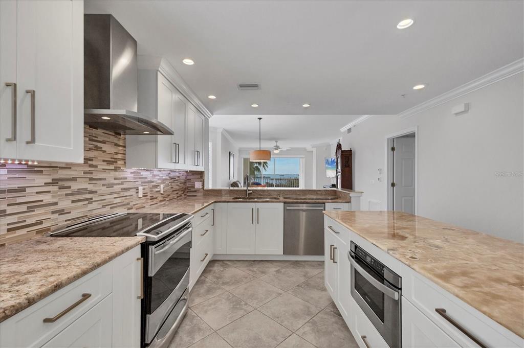 13313 Gasparilla Road, Unit C401 Placida, FL 33946 - Photo 9 of 30 a kitchen with stainless steel appliances granite countertop a sink and stove top oven