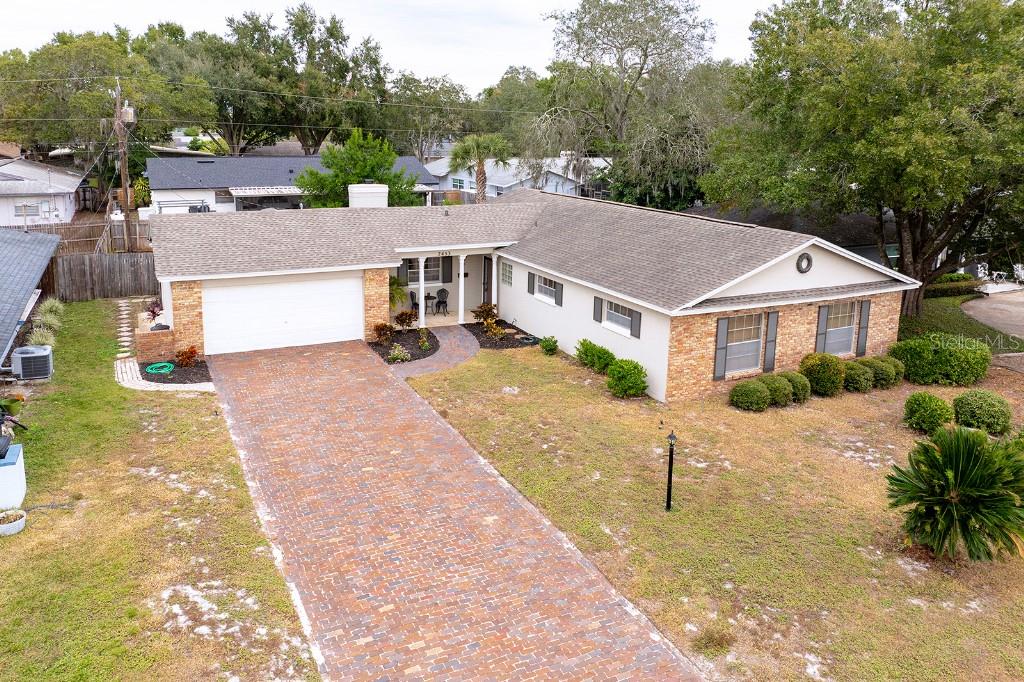 2453 Worthington Road Maitland, FL 32751 - Photo 21 of 22 a view of a white house with a yard plants and large tree