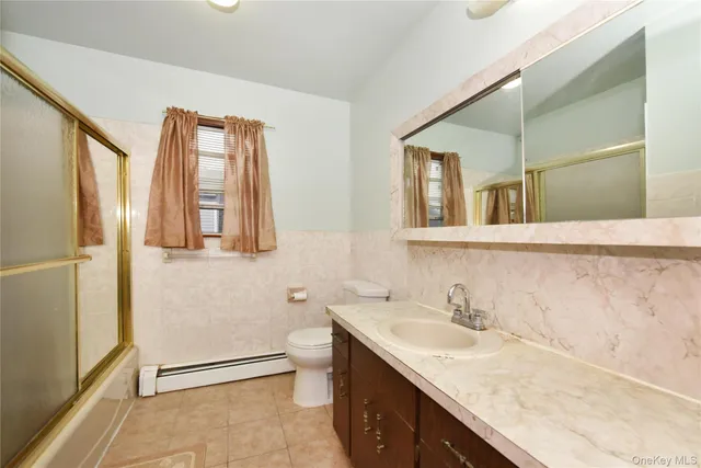 a bathroom with a granite countertop sink and mirror with bathtub