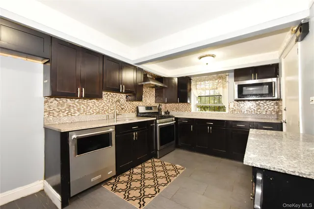 a kitchen with stainless steel appliances kitchen island granite countertop a sink stove and oven