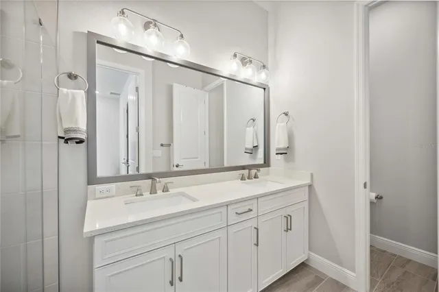 a bathroom with a double vanity sink a mirror and a shower