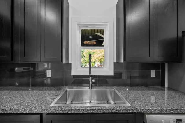 a kitchen with granite countertop a sink a refrigerator and a granite counter tops