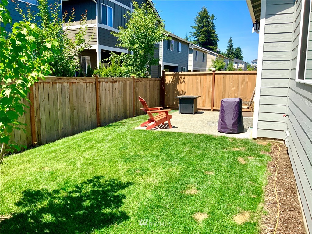 5107 Kenrick Street Southeast Lacey, WA 98503 - Photo 30 of 31 a backyard of a house with table and chairs wooden fence