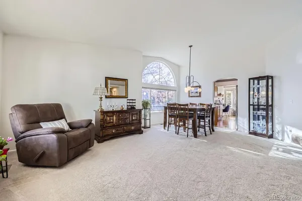 a living room with furniture a chandelier and a large window