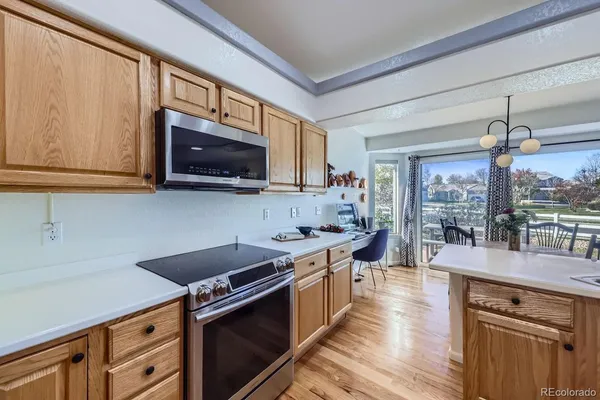 a living room with furniture a flat screen tv and kitchen view