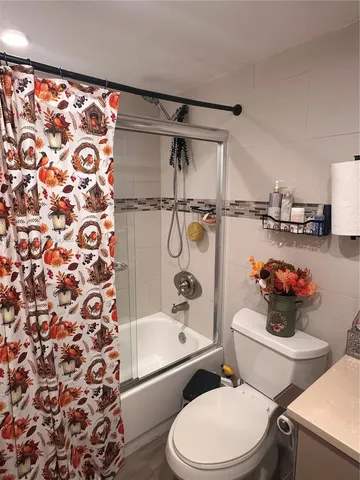 a white toilet sitting next to a bathroom sink and a bathtub