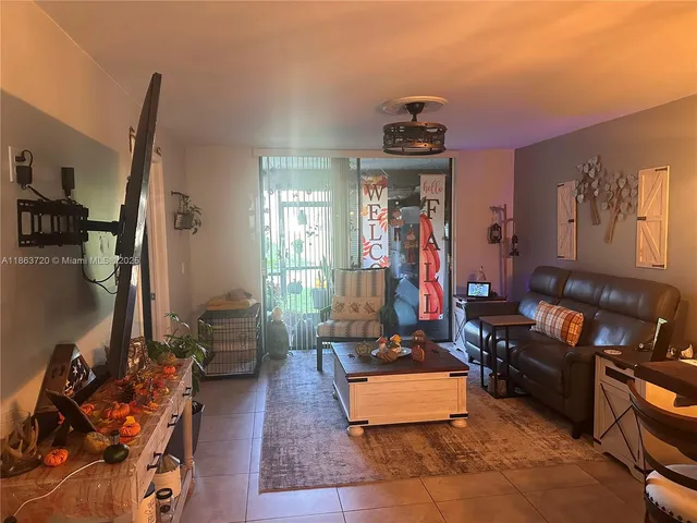 a living room with furniture a flat screen tv and a gym equipment
