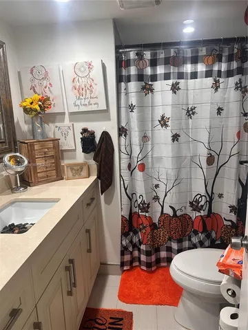 a bathroom with a sink mirror vanity and toilet