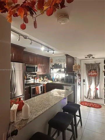 a kitchen with kitchen island a large counter top appliances and cabinets