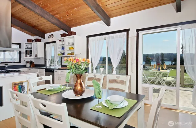 a view of a dining room with furniture large windows and wooden floor