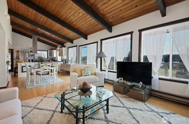 a living room with furniture a flat screen tv and a table