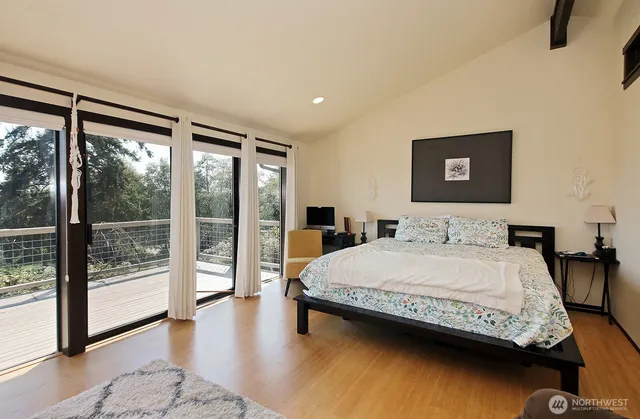 a bedroom with a bed and a large window