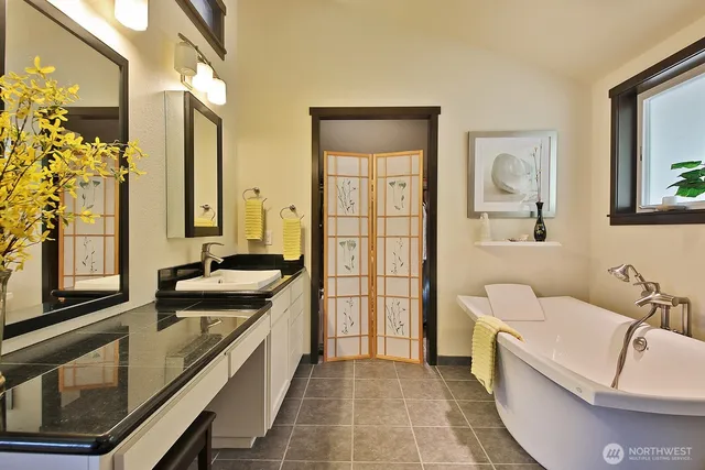 a bathroom with a granite countertop sink and a large mirror