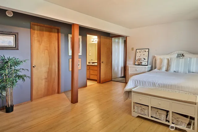 a spacious bedroom with a balcony and dresser