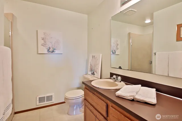 a bathroom with a granite countertop sink a toilet and a mirror