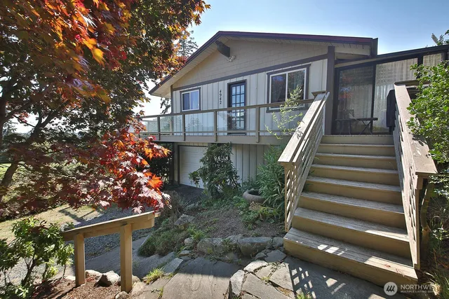 a front view of a house with plants and entryway