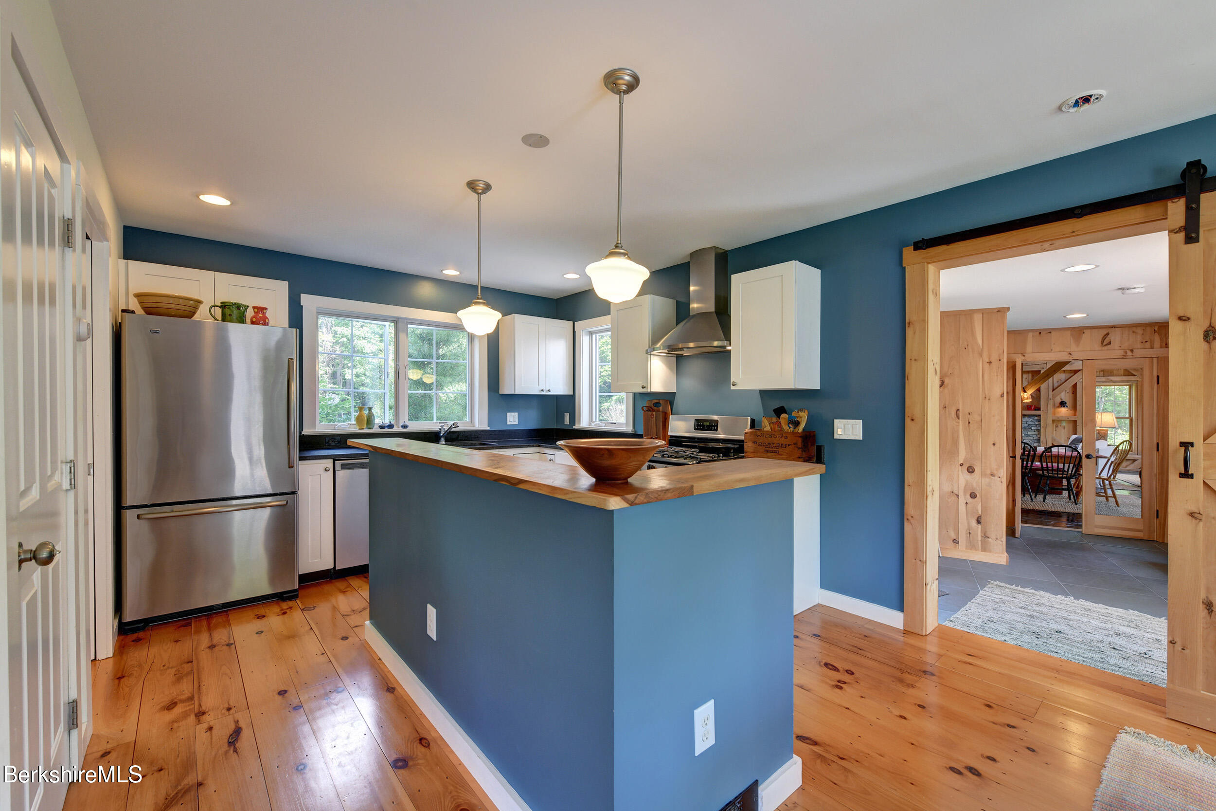 66 Access Road Becket, MA 01223 - Photo 25 of 54 a kitchen with stainless steel appliances granite countertop a refrigerator a sink dishwasher a stove and a dining table with wooden floor