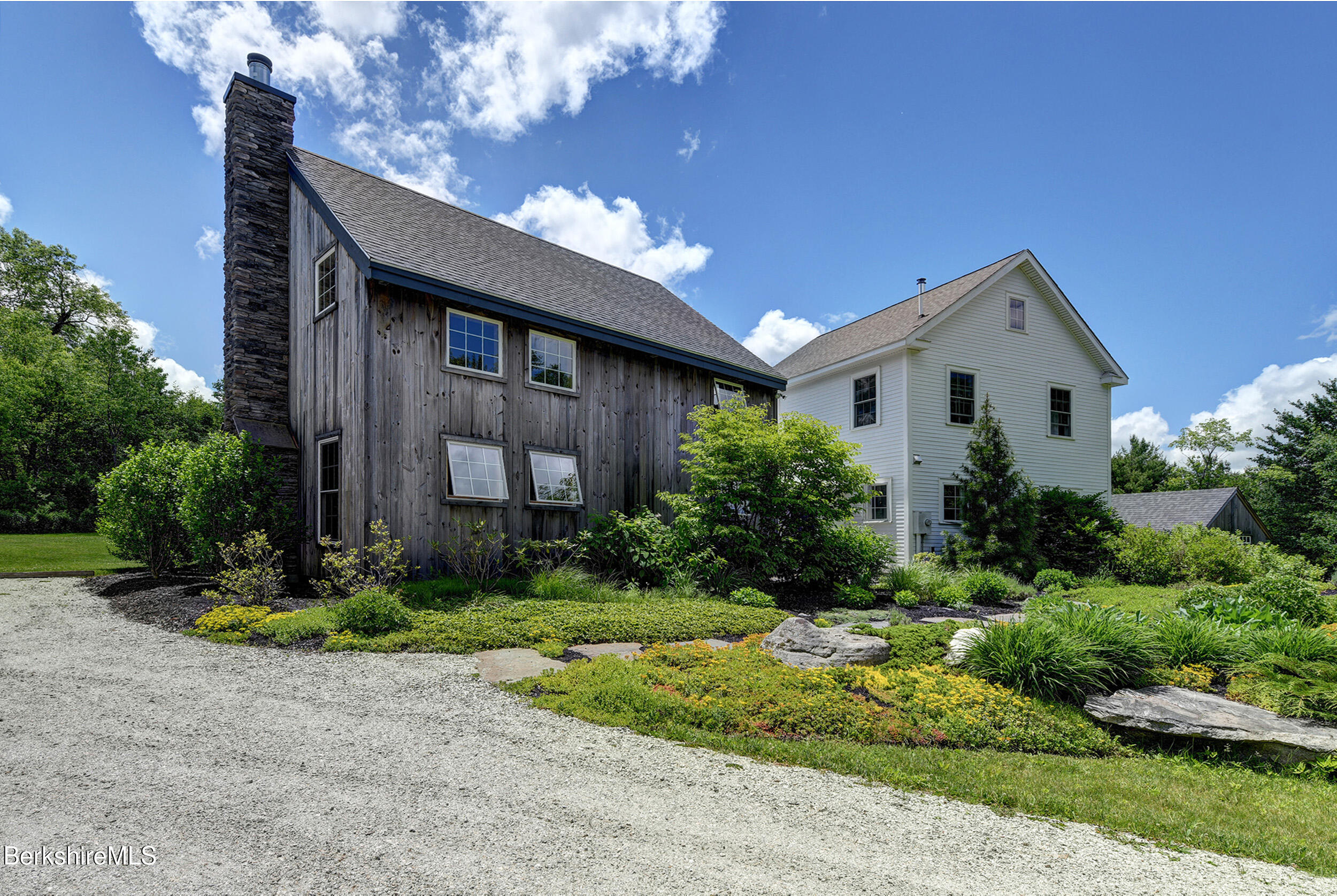 66 Access Road Becket, MA 01223 - Photo 3 of 54 a front view of a house with garden
