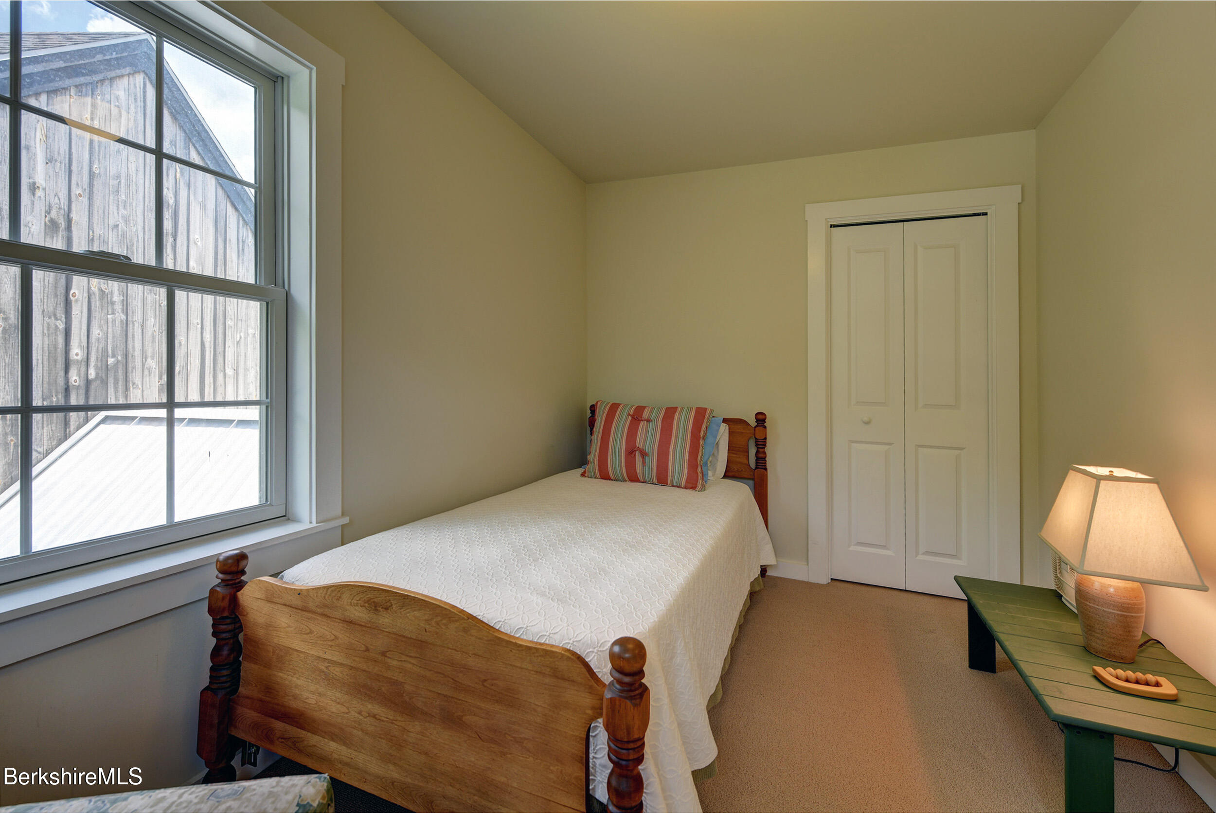 66 Access Road Becket, MA 01223 - Photo 36 of 54 a bedroom with a bed a mirror on dresser and a window