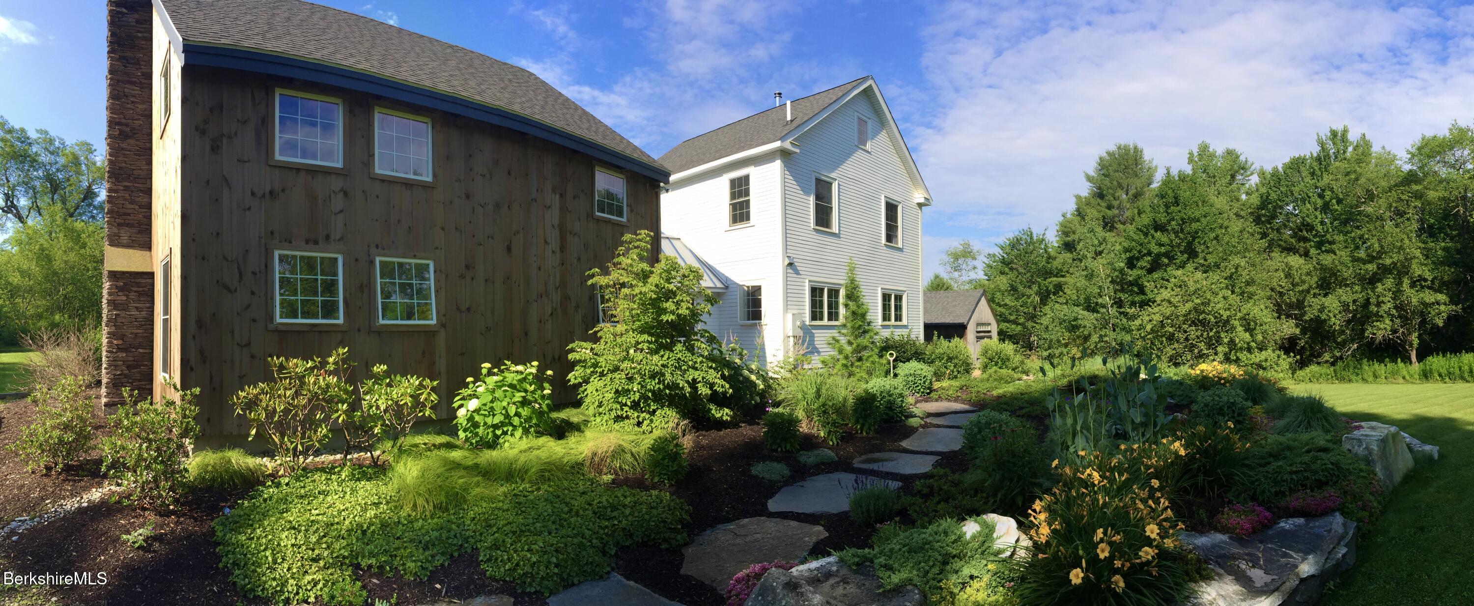 66 Access Road Becket, MA 01223 - Photo 50 of 54 a front view of a house with plants and trees
