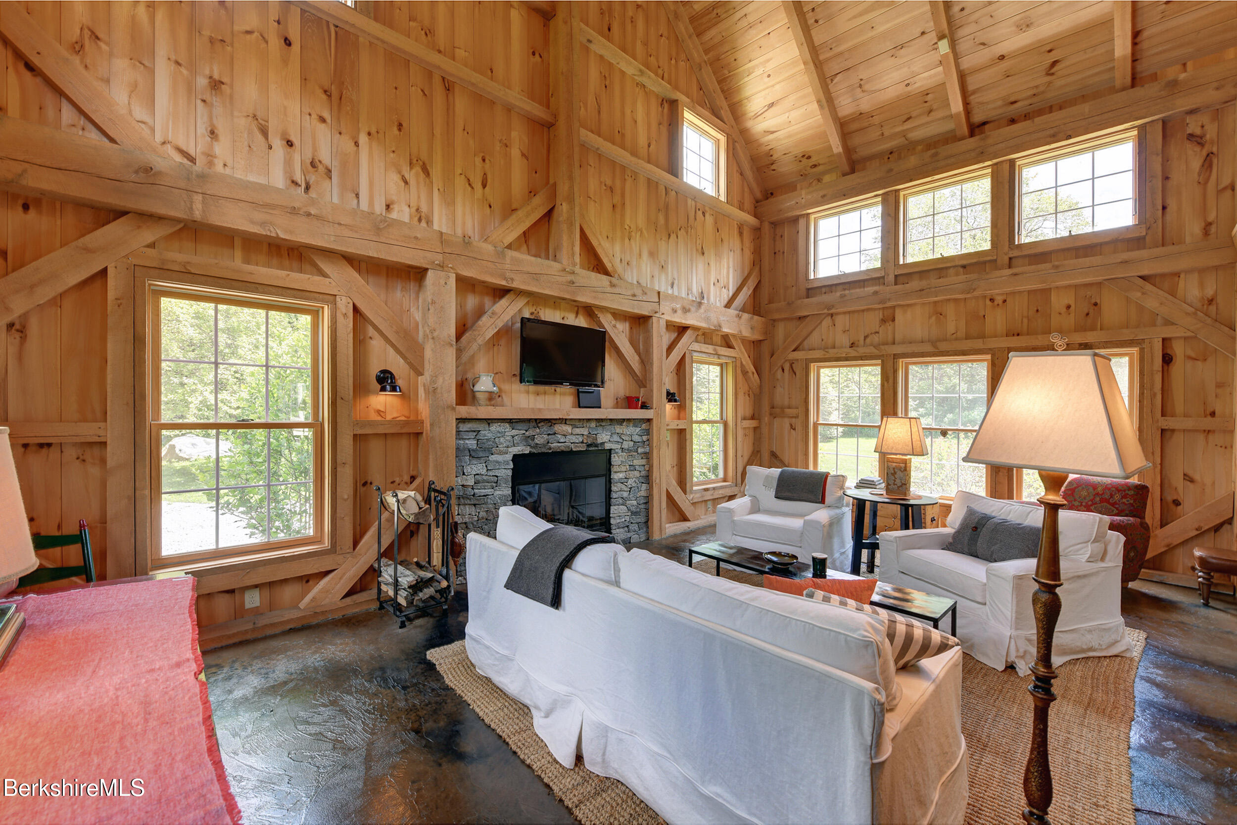 66 Access Road Becket, MA 01223 - Photo 10 of 54 a living room with furniture a fireplace and a floor to ceiling window