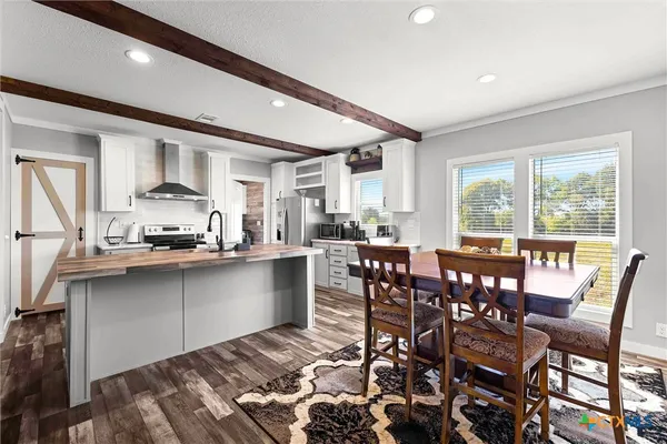 a kitchen with kitchen island granite countertop a sink cabinets and stainless steel appliances