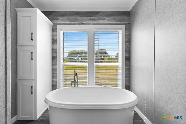 a bathroom with a white toilet and a window