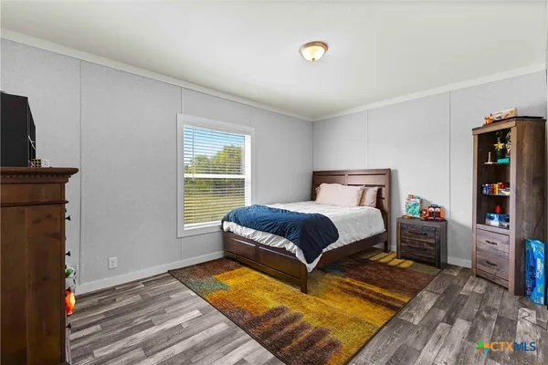 a bedroom with a bed and a lamp on the dresser