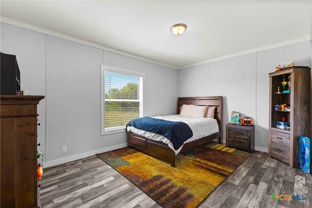 a bedroom with a bed and a lamp on the dresser