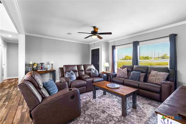 a living room with furniture kitchen view and a window