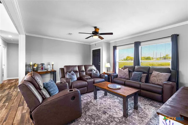 a living room with furniture kitchen view and a window