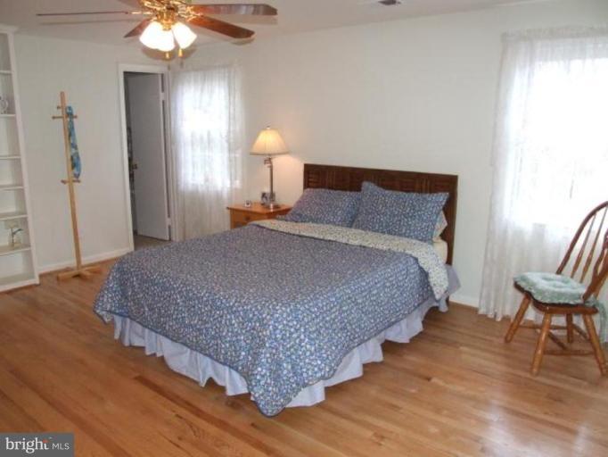 12409 Over Ridge Road Potomac, MD 20854 - Photo 2 of 30 a bedroom with a bed lamps and wooden floor