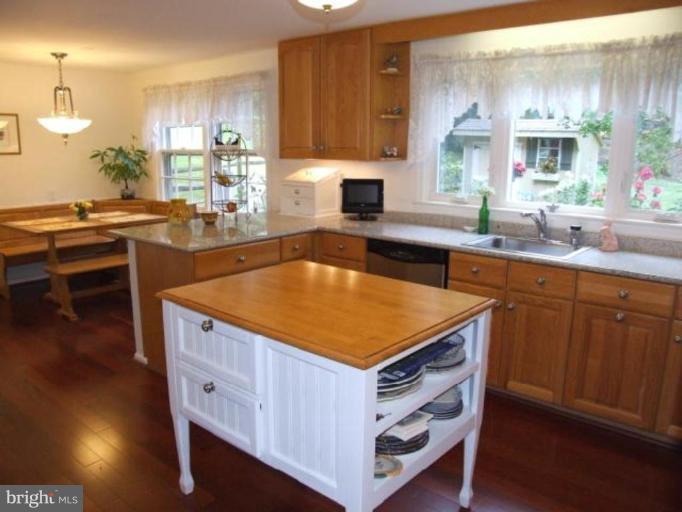 12409 Over Ridge Road Potomac, MD 20854 - Photo 14 of 30 a kitchen with kitchen island granite countertop a sink cabinets and wooden floor
