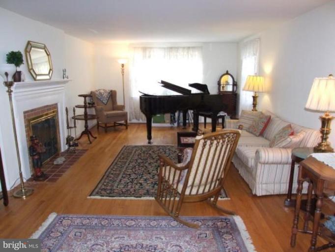 12409 Over Ridge Road Potomac, MD 20854 - Photo 16 of 30 a living room with furniture a fireplace and a table