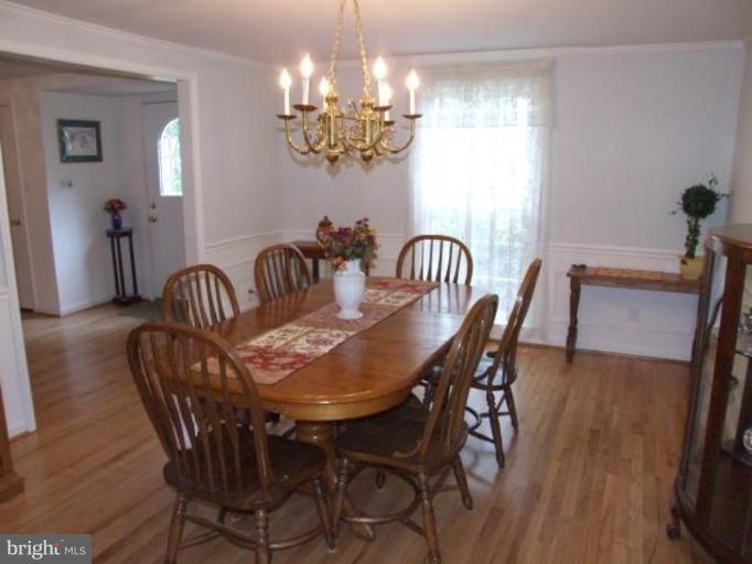 12409 Over Ridge Road Potomac, MD 20854 - Photo 7 of 30 a dining room with furniture a chandelier and wooden floor
