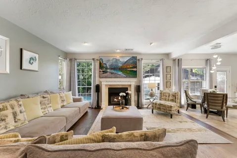 a living room with furniture large window and a fireplace