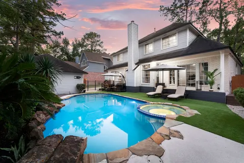 a view of a house with swimming pool and a yard