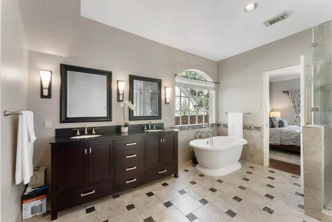 a spacious bathroom with a bathtub sink and mirror