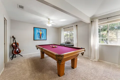 a room with pool table and windows