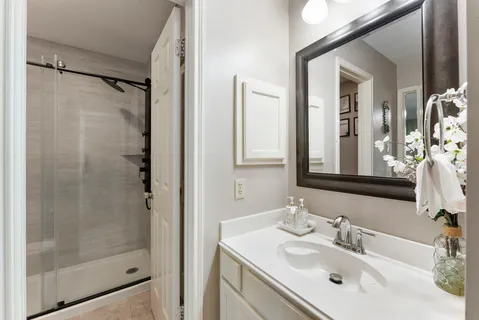 a bathroom with a shower sink vanity and mirror