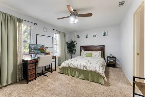 a spacious bedroom with a bed and a chandelier