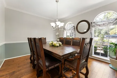 a dining room with furniture a chandelier and wooden floor