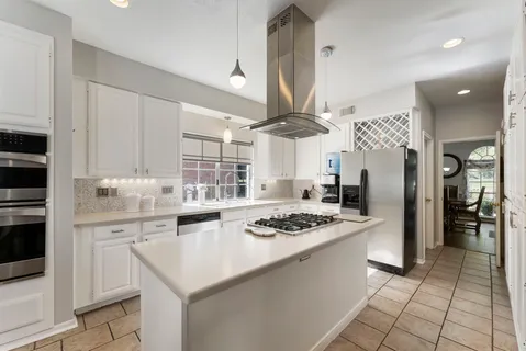 a kitchen with stainless steel appliances granite countertop a sink a stove and refrigerator