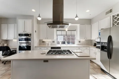 a kitchen with stainless steel appliances a stove a sink a refrigerator and cabinets